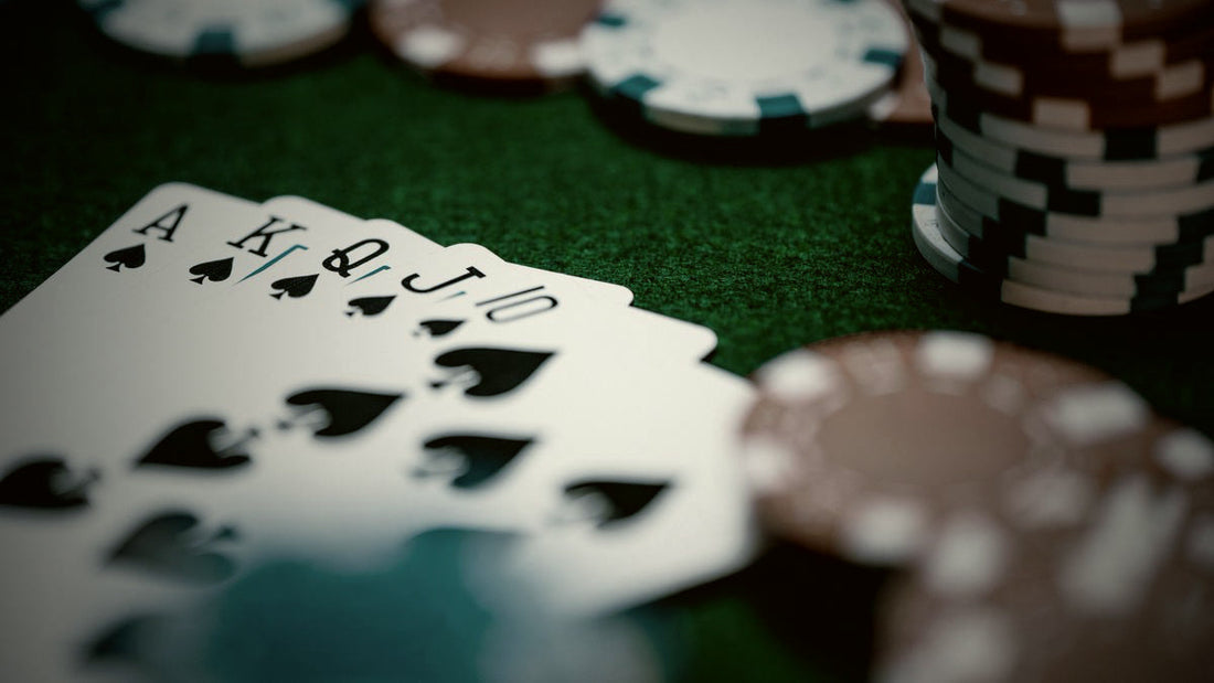 Quinte flush royale a pique posee sur un tapis de poker avec des jetons, illustration de la main la plus forte au classement des mains au poker