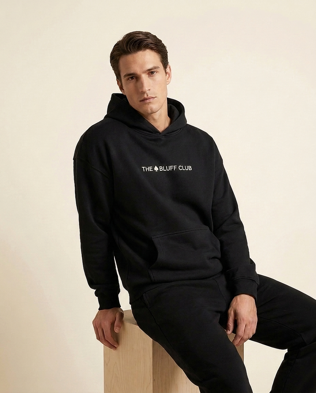 Hoodie Noir — studio assis (brodé)