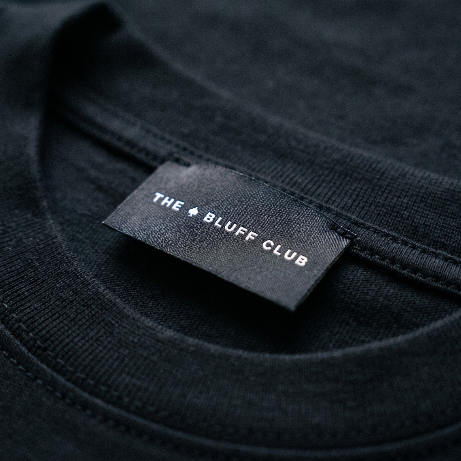 Étiquette tissée THE BLUFF CLUB cousue au col — SIGNATURE · T-shirt MAISON DE JEU
